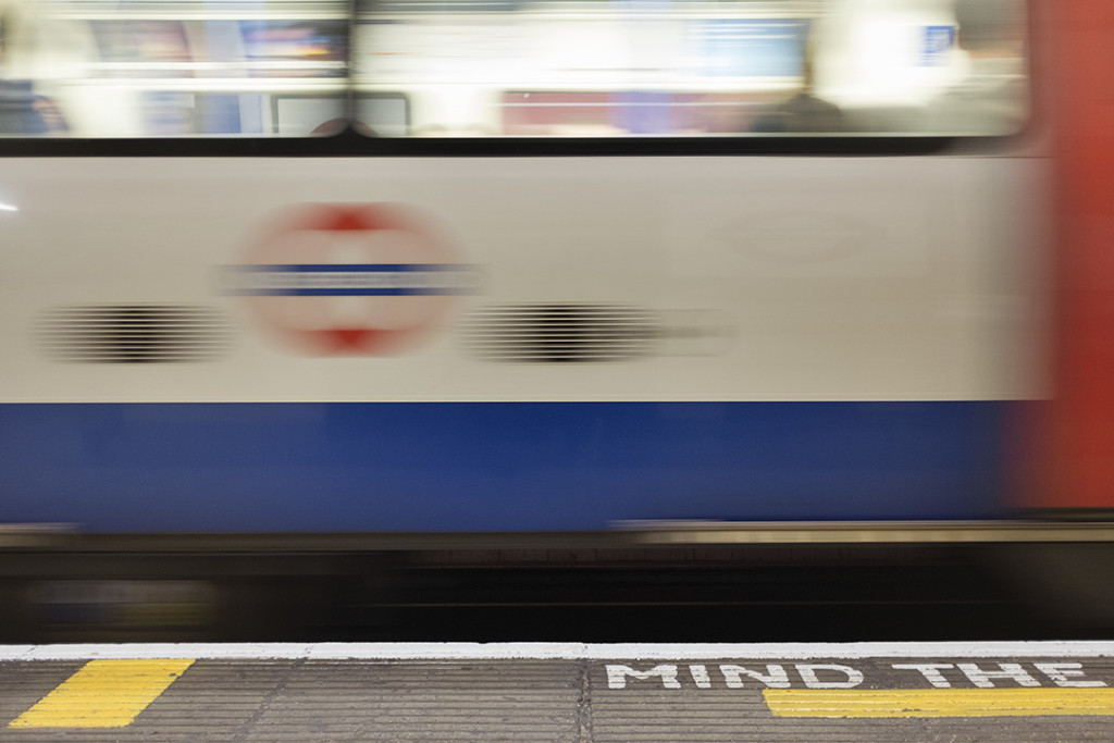 London underground train moves in front of mind the gap signal